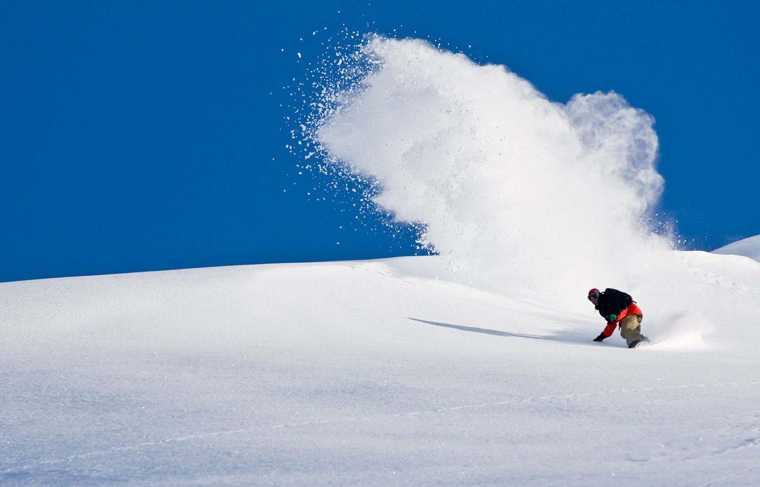 Szeroki, sztywny snowboard z uniesioną łopatą nosa do szusowania w głębokim puchu