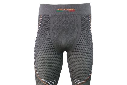 Mężczyzna w pełnym zestawie bielizny termoaktywnej z kompresją stoi na zaśnieżonym stoku narciarskim