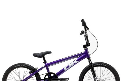 Kolarz na rowerze BMX skacze wysoko nad rampą w skateparku miejskim