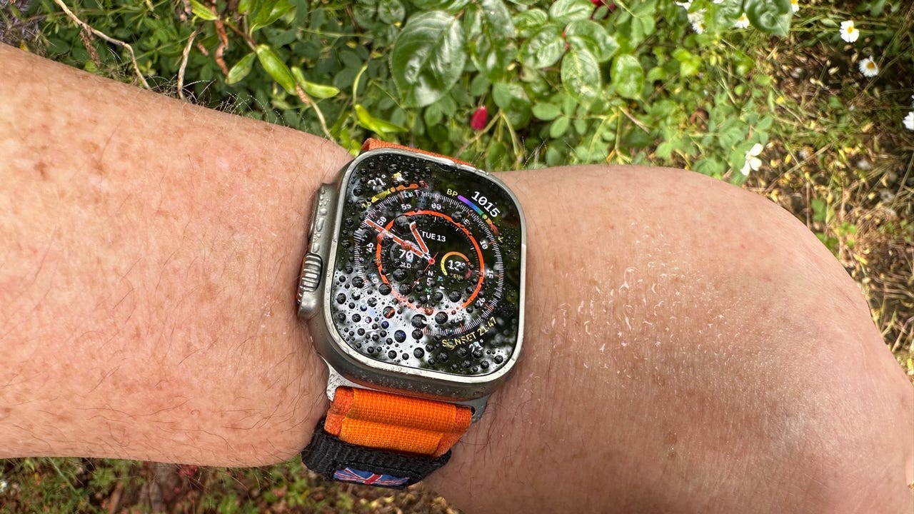 Ekran Garmina Fenix 7 pokazujący mapę trasy na tle ręki sportowca w górach