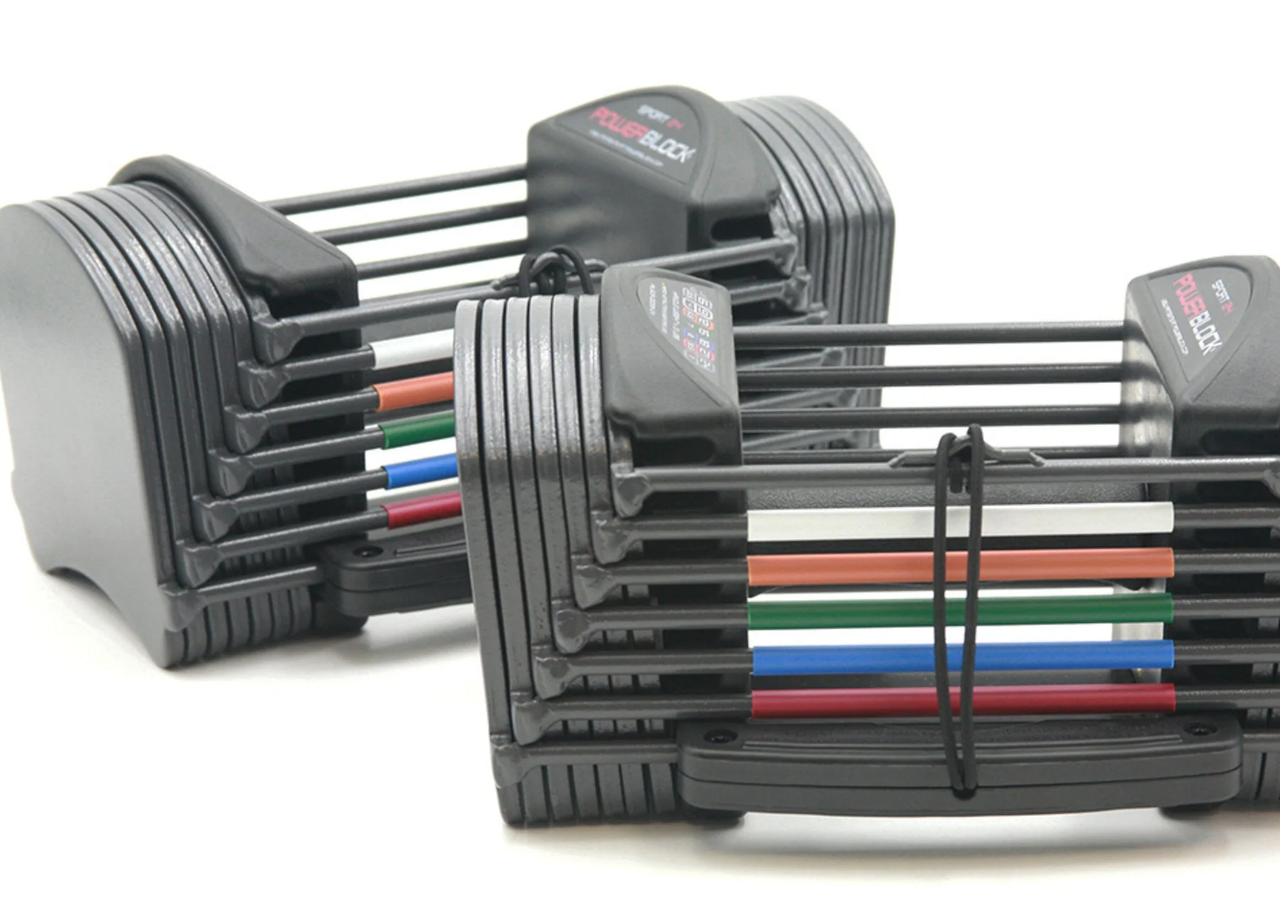 mechanizm regulacji pinem w PowerBlock ręka wciskająca pin blokujący w otwory hantli PowerBlock Sport