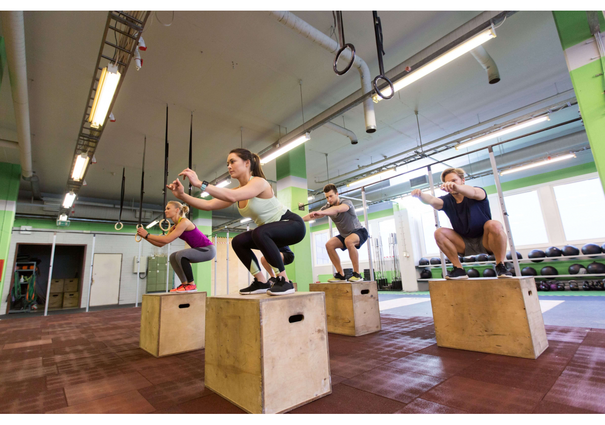 kobieta robiąca przysiady z rękami wyciągniętymi do przodu na macie jogowej