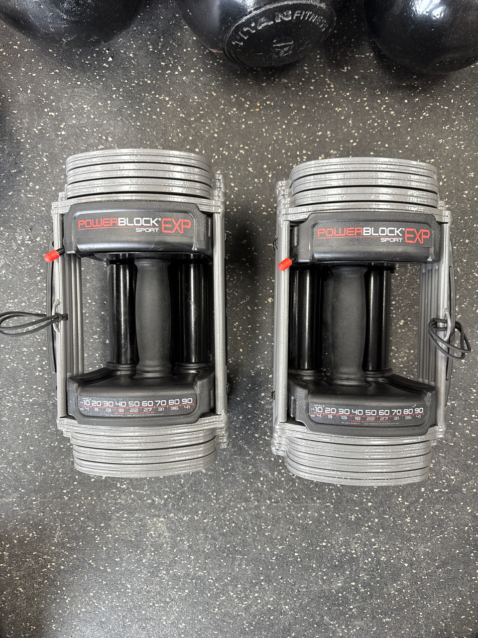 przysiady goblet z regulowanym PowerBlock kobieta robiąca przysiady goblet z hantlą PowerBlock Sport w domu