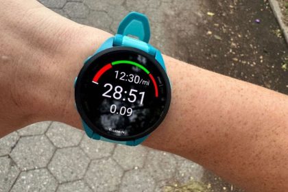 mężczyzna w koszulce biegowej z zegarkiem GPS na nadgarstku biegnący parkiem